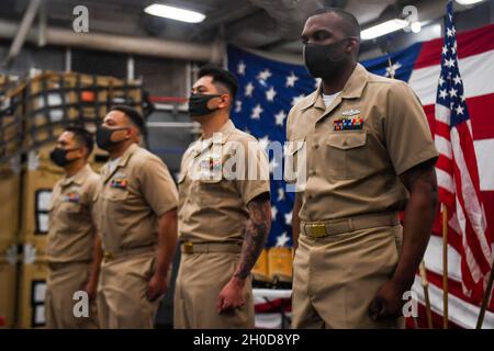 210129-N-UM706-1088 PHILIPPINE SEA (Jan. 29, 2021) Sailors prepare to be pinned as Chief Petty Officers aboard the amphibious dock landing ship USS Ashland (LSD 48). From right to left: Chief Engineman Lorenzo Awa, from Atlanta; Chief Information Systems Technician Michael Casao, from Murrieta, Calif.; Chief Culinary Specialist Desmond Moore, from Bennettsville, S.C.; Chief Hospital Corpsman Mark Miranda, from Manila, Philippines. Ashland, part of the America Expeditionary Strike Group, along with the 31st Marine Expeditionary Unit, is operating in the U.S. 7th Fleet area of responsibility to Stock Photo