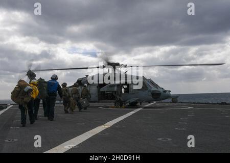 210129-N-UM706-1459 PHILIPPINE SEA (Jan. 29, 2021) Marines assigned the 31st Marine Expeditionary Unit (MEU) embark an MH-60S Sea Hawk helicopter, from Helicopter Sea Combat Squadron (HSC) 25, aboard the amphibious dock landing ship USS Ashland (LSD 48). Ashland, part of the America Expeditionary Strike Group, along with the 31st MEU, is operating in the U.S. 7th Fleet area of responsibility to enhance interoperability with allies and partners, serving as a ready response force to defend peace and stability in the Indo-Pacific region. Stock Photo