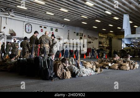 U.S. Marines and Sailors with Combat Logistics Battalion (CLB) 31, 31st Marine Expeditionary Unit (MEU), stand by during a nightingale drill aboard amphibious assault ship USS America (LHA 6) in the Philippine Sea, Jan. 29, 2021. Nightingale is the 31st MEU’s quick response force for mass casualty evacuations. The 31st MEU is operating aboard ships of the America Expeditionary Strike Group in the 7th fleet area of operations to enhance interoperability with allies and partners and serve as a ready response force to defend peace and stability in the Indo-Pacific region. Stock Photo