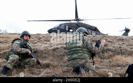 Turkish Armed Forces soldiers assigned to Regional Command-East, Kosovo Force, wait for a signal to board a UH-60 Blackhawk after conducting a foot patrol along the administrative boundary line in Kosovo on Feb. 1, 2021. The platoon took a flight from Camp Bondsteel to be dropped off at a point on the ABL. KFOR regularly patrols the ABL to maintain the safety and security of people in the region. Stock Photo
