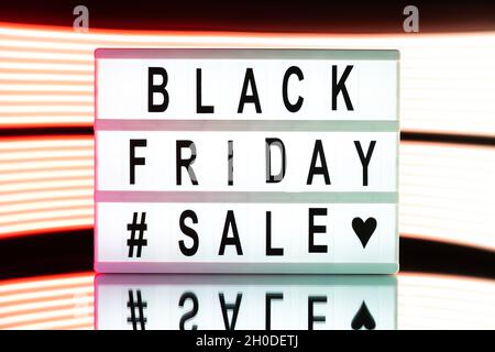 Black friday sale written on information light boxing sign on bright neon background. Stock Photo