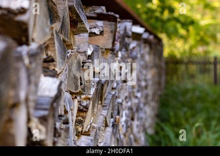 closeup of chopped firewood in green rural environment. Woodpile stacked and prepared for winter Pile of wood logs. Stock Photo