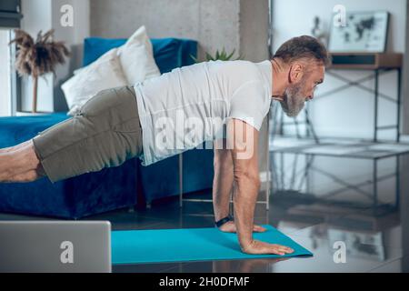 A mature man having a worout and doing push ups Stock Photo