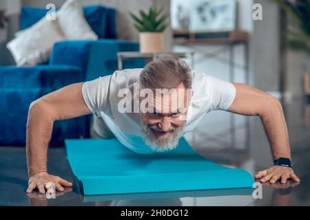 A mature man having a worout and doing push ups Stock Photo