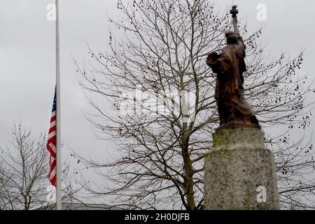 The American flag is flown at half-staff to honor the passing of Captain Sir Tom Moore at Royal Air Force Lakenheath, England, Feb. 3 , 2021. At 100 years old, Moore raised £33 million for United Kingdom National Health Service charities by walking laps of his garden during the COVID-19 pandemic. Stock Photo