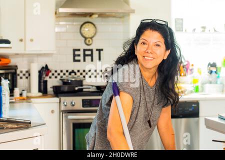 Latin woman cleaning The kitchen Stock Photo