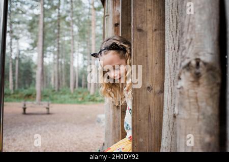 portrait of a girl climbing a tree house in the forest Stock Photo