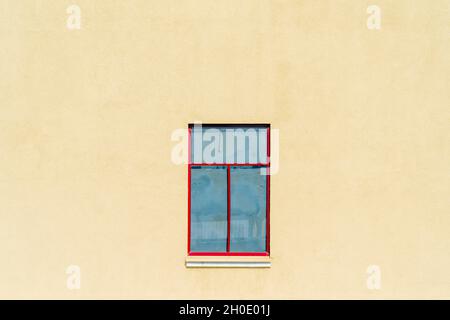 Small window in the yellow wall. Modern architecture. Stock Photo