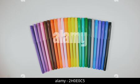 Many colored pencils are arranged around the edges of the image as a frame. In the center is an empty background with space for text. Stock Photo