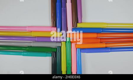 Many colored pencils are arranged around the edges of the image as a frame. In the center is an empty background with space for text. Stock Photo