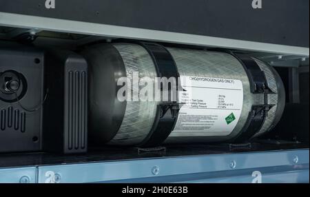 Bus with an open hood and a hydrogen cylinder inside Stock Photo