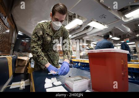 210213-N-QD512-1040 NORFOLK, Va. (Feb. 13, 2020) Hospital Corpsman 3rd Class Austin Hurt, from Las Vegas, prepares COVID-19 vaccinations aboard the Arleigh-Burke class guided-missile destroyer USS Mitscher (DDG 57). Mitscher is currently pier side conducting routine maintenance. Stock Photo
