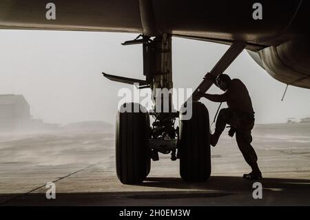 U.S. Air Force Senior Airman Eric Cruz, a crew chief with the 379th Expeditionary Aircraft Maintenance Squadron, prepares for the hot refuel of a U.S. Air Force KC-135 Stratotanker aircraft at Doha Air Base, Qatar, Jan. 21, 2021. Airmen with the 379th Air Expeditionary Wing’s Logistics Readiness and Aircraft Maintenance Squadrons at Al Udeid AB worked with their Qatari Emiri Air Force partners to conduct the remote refueling operation from Doha AB. Stock Photo