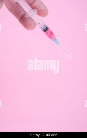 sterilized injection syringe on a pink background Stock Photo