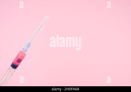 sterilized injection syringe on a pink background Stock Photo