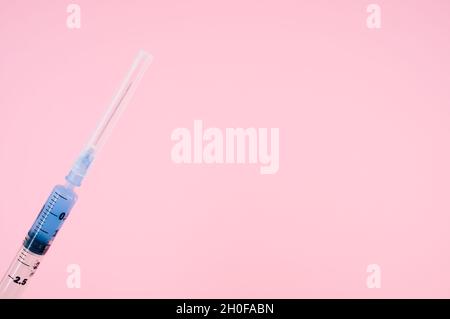 sterilized injection syringe on a pink background Stock Photo