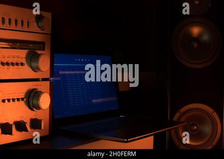 Laptop playing music on big loudspeakers with amplifier. Home sound system concept Stock Photo