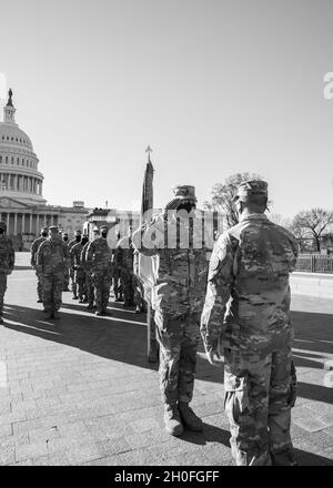 U.S. Army Command Sgt. Maj. William Russell III, senior enlisted advisor to the adjutant general, Michigan National Guard, salutes Col. Chirs McKinney, commander of the 177th Military Police Brigade, at the U.S. Capitol in Washington, D.C., Feb. 25, 2021. The National Guard has been requested to continue supporting federal law enforcement agencies with security, communications, medical evacuation, logistics, and safety support to state, district and federal agencies through mid-March. Stock Photo