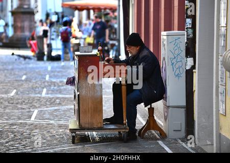 Man playing piano busking on cobbled street in Freiburg Germany Stock Photo