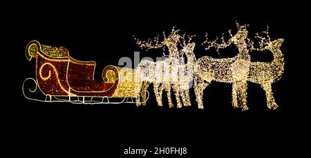 Christmas reindeer from light bulbs with red sleigh of Santa Claus on a black isolated background. Christmas, New Year. Copy space Stock Photo