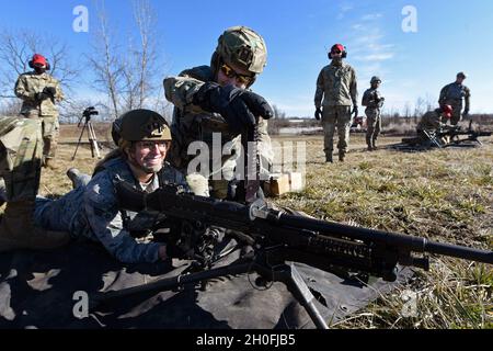 U.S. Air Force Senior Airman Aurielle Marvin, an 88th Security Forces Squadron patrolman, and Airman 1st Class Michael Lawhead, an 88th SFS alarm monitor, work together to operate the M240B machine gun at Camp Atterbury in Edinburgh, Indiana, on Feb. 25, 2021. Members of the 88th SFS, travel to Camp Atterbury multiple times each year for readiness and qualification training with deployers on machine guns and grenade launchers. Stock Photo