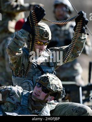 U.S. Air Force Airman 1st Class Michael Lawhead, an 88th Security Forces Squadron alarm monitor, prepares to load an M240B machine gun with Staff Sgt. Sawyer McIntyre, an 88th SFS combat arms instructor, at Camp Atterbury in Edinburgh, Indiana, on Feb. 25, 2021. The combat arms instructors, from Wright-Patterson Air Force Base, Ohio, travel to Camp Atterbury multiple times each year for readiness and qualification training with deployers on machine guns and grenade launchers. Stock Photo