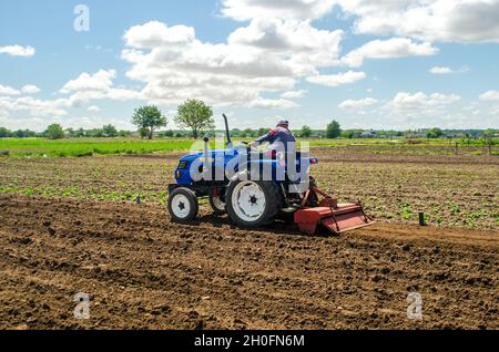 Kherson oblast, Ukraine - May 28, 2020: A farmer is cultivating a field before replanting seedlings. Milling soil, crushing and loosening ground befor Stock Photo