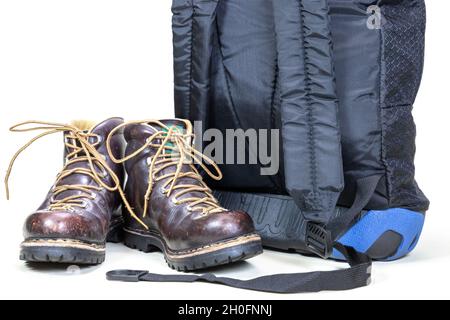 Studio shot of a pair of vintage leather hiking boots next to a backpack Stock Photo