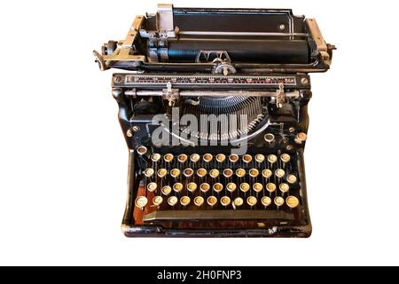 An old vintage Typewriter with spanish keyboard over a wooden desk, isolated on white background Stock Photo
