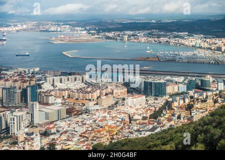 Elevated view of part of the town of Gibraltar, looking over the airport runway and Alcaidesa Marina to CEPSA's Gibraltar-San Roque Refinery. Stock Photo