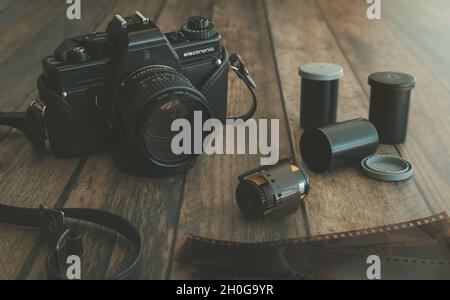 Closeup of Vintage Film Camera with Filmstrip and Rolls of Film Stock Photo