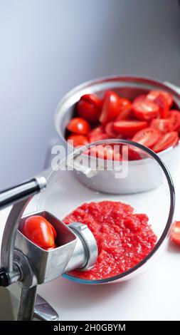 Manual vintage meat grinder and ripe tomatoes on the table. Making homemade  tomato sauce. Use of outdated kitchen utensils Stock Photo - Alamy