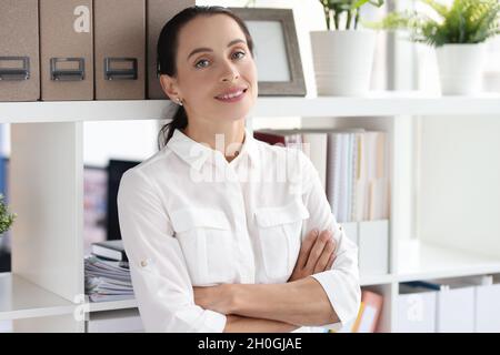 Portrait of young beautiful smiling woman in office closeup Stock Photo