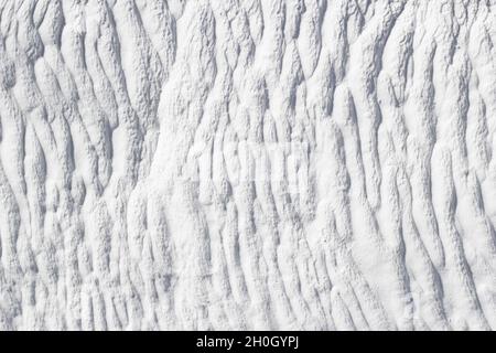 White texture of Pamukkale calcium travertine in Turkey, pattern of vertical lines, close-up. Stock Photo