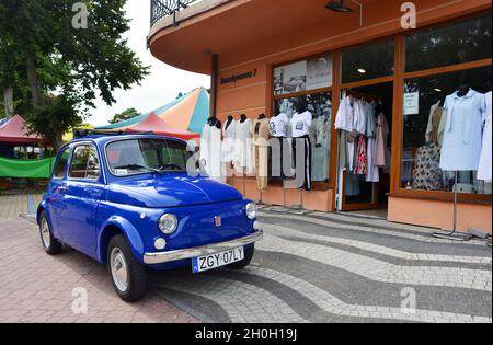 Niechorze, Poland, vintage Fiat car in blue in front of a fashion shop Stock Photo