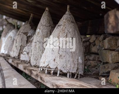Old traditional beehive knitted with wicker and covered with mud on wooden shelf Stock Photo