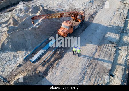 Aerial image of two engineers with helmets and vests walking at construction site Stock Photo