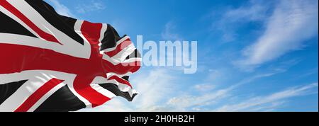 United Kingdom black and red flag at cloudy sky background on sunset. panoramic view. united kingdom of great Britain, England. copy space for wide ba Stock Photo