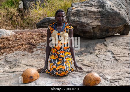Young girls grinding Sorghum on a rock, Laarim tribe, Boya hills, Eastern Equatoria, South Sudan Stock Photo