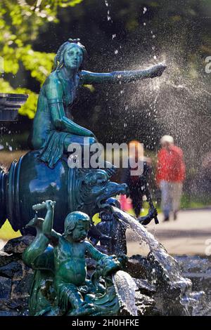 Nymph, dragon, water spouting, putto, child figure with club, riding, Neptune fountain with figures from Greek mythology, behind walker, municipal Stock Photo