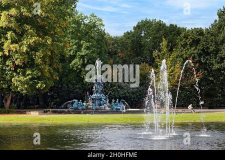 Pond, pond with fountain, in the back Neptune fountain with figures from Greek mythology, surrounded by tall trees, municipal park, Nuremberg, Middle Stock Photo