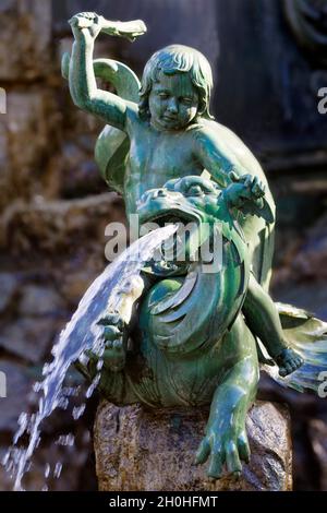 Dragon, water spouting, putto, child figure with club, riding, Neptune fountain with figures from Greek mythology, municipal park, Nuremberg, Middle Stock Photo