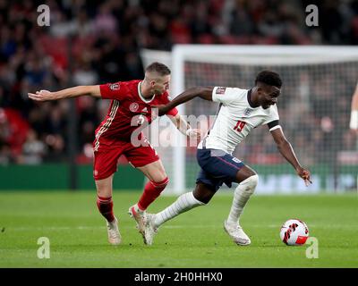 London, UK. 12th Oct, 2021. England's Bukayo Saka (R) is challenged by Hungary's Zsolt Nagy during the FIFA World Cup Qatar 2022 qualification group I match between England and Hungary in London, Britain on Oct. 12, 2021. Credit: Matthew Impey/Xinhua/Alamy Live News Stock Photo