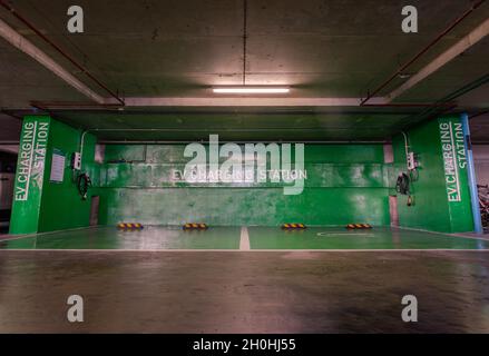 Bangkok, Thailand - Aug 26, 2021 : Front view of electric vehicle charging station and battery on the wall in a building parking lot, Fast battery exc Stock Photo