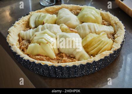 Cake with pears and peaches in metal mold is ready for baking in an electric oven Stock Photo