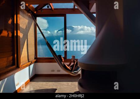 View of San Pedro volcano and Lake Atitlan from a hammock, San Marcos, Guatemala Stock Photo