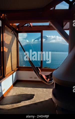 View of San Pedro volcano and Lake Atitlan from a hammock, San Marcos, Guatemala Stock Photo