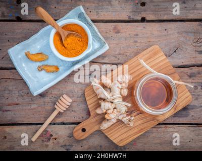 Alternative skin care - Homemade scrubs curcumin powder,honey and curcumin roots set up on old wooden table. Stock Photo