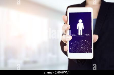 Social media concept. Communication network. Hand hold white smartphone with digital hologram Human, Leader sign on light blurred background. Customer Stock Photo