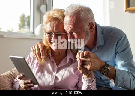 Elderly couple using tablet for communication with family Stock Photo